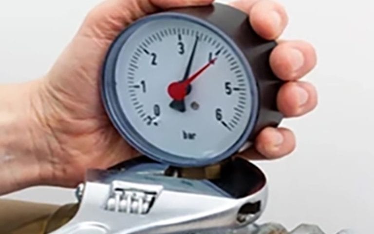 Installing a pressure gauge using a wrench on the connector