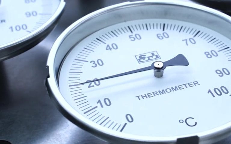 Close-up of industrial dial thermometer face
