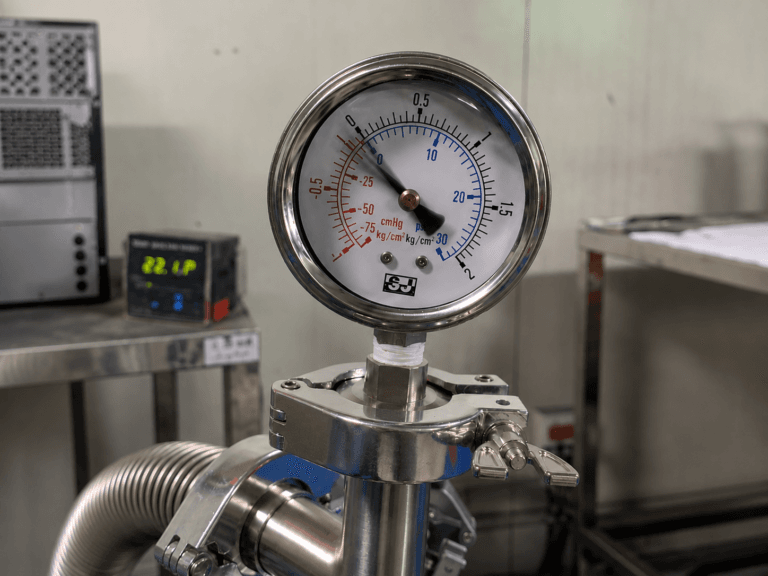 Stainless steel pressure gauge showing slight pointer vibration during industrial process operation